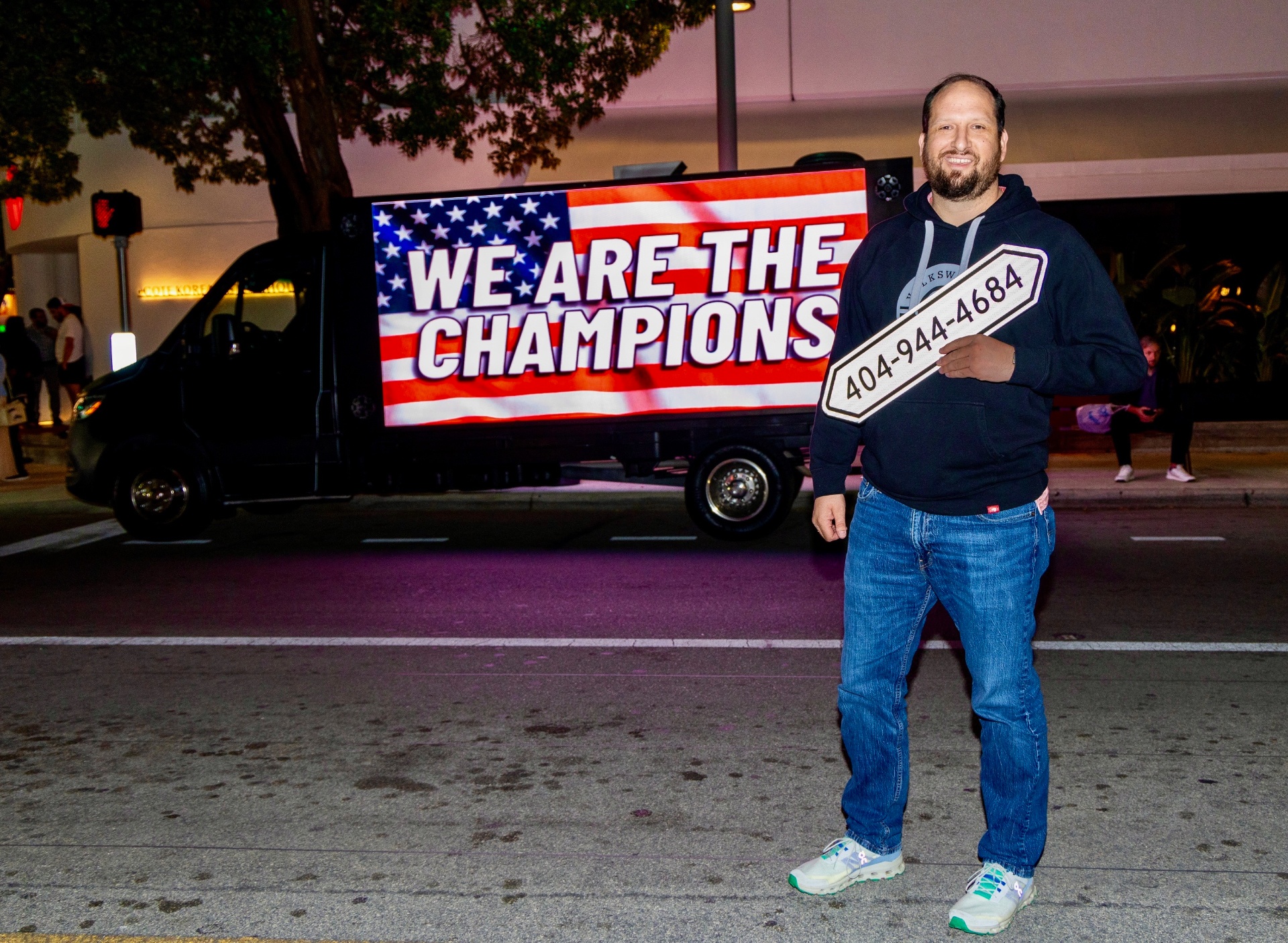 Nick Joyce standing beside a Presidential Advertising LED truck at night